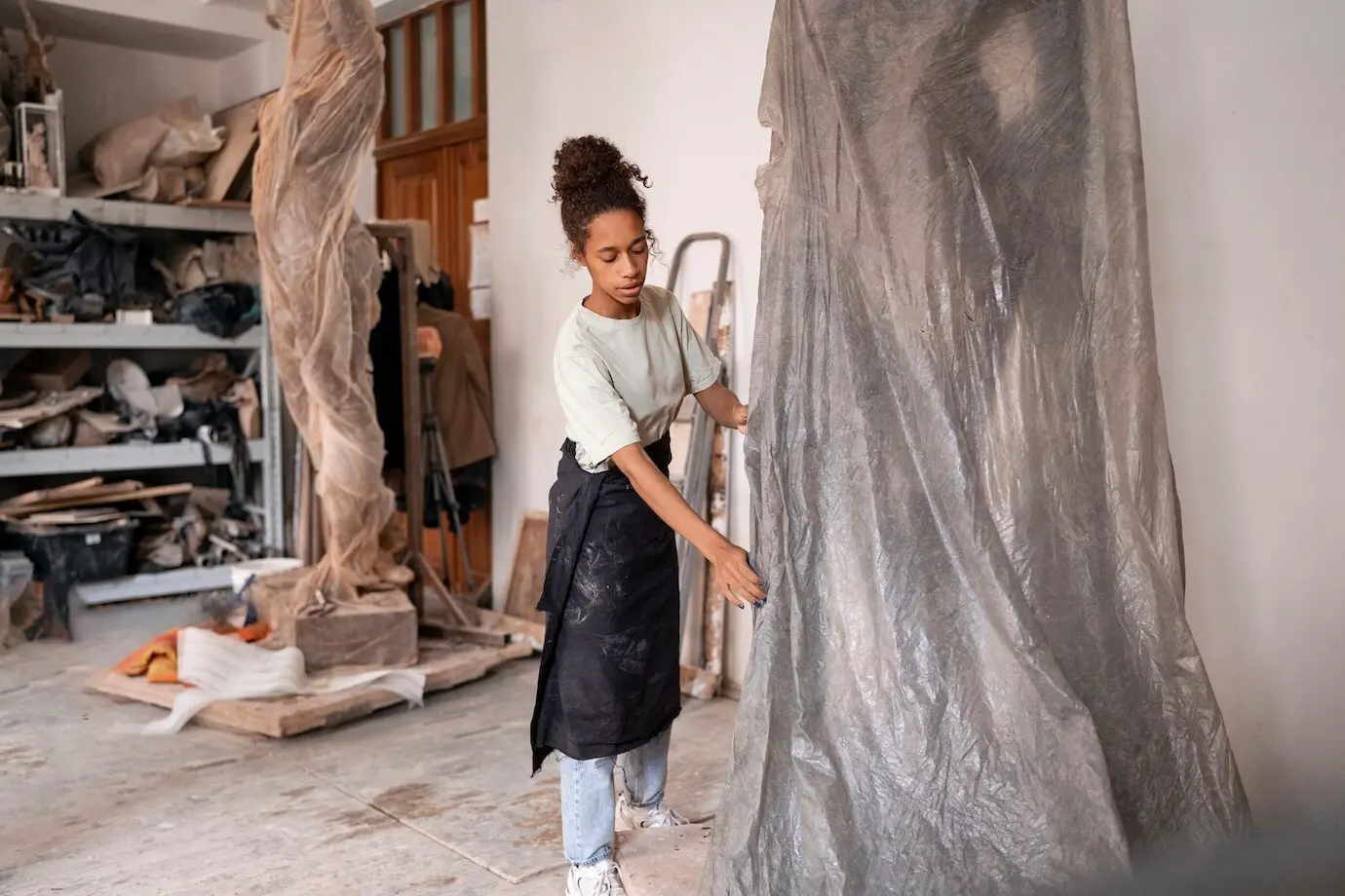 Ganzkörperaufnahme einer Frau, die Ton modelliert.